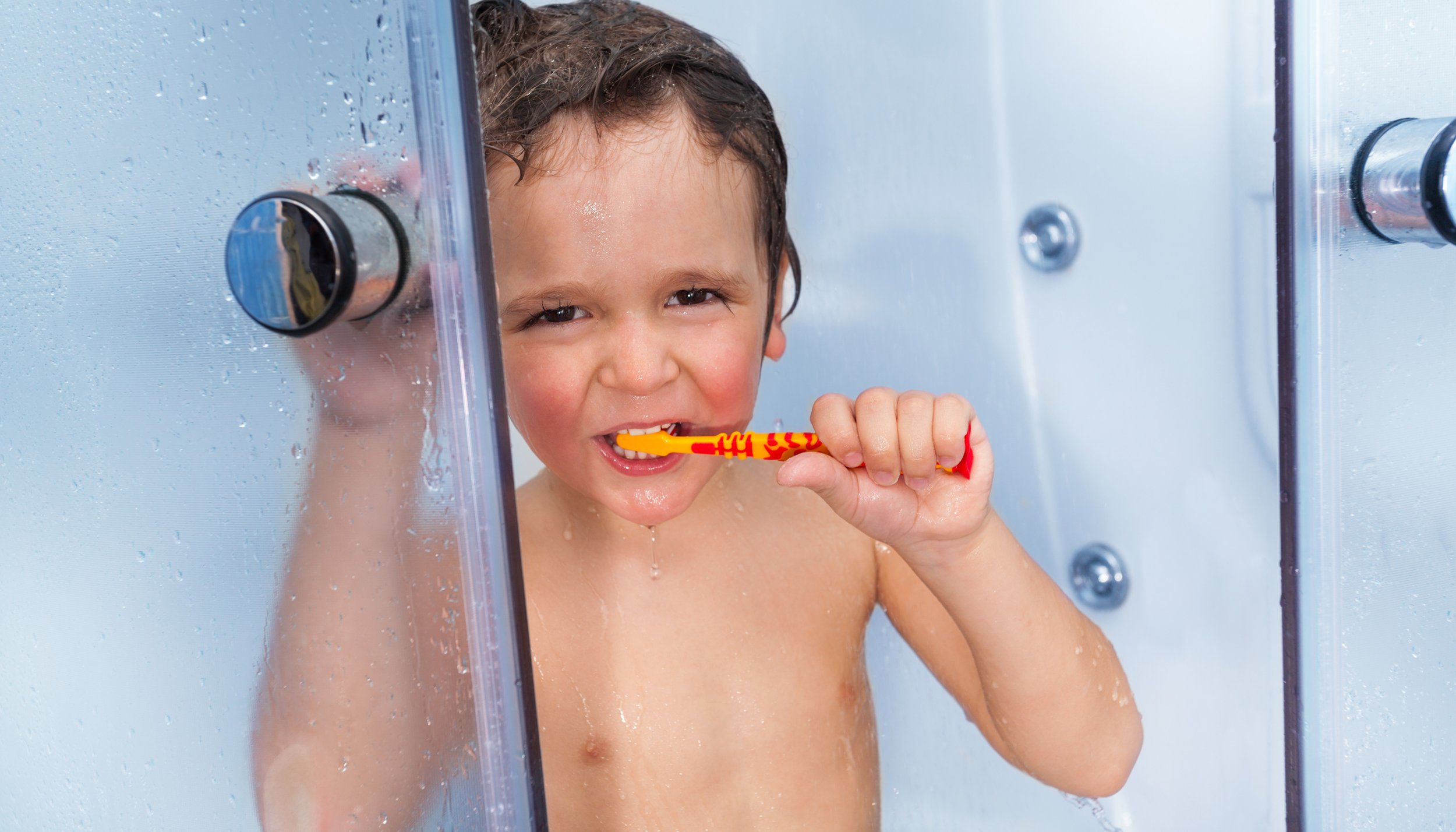 liten gutt pusser tenner i dusjen